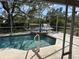 Screened-in pool and hot tub in backyard with a view of the water and fountain at 4538 Hamlets Grove Dr, Sarasota, FL 34235
