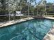 Enclosed swimming pool and spa with screened enclosure and view of the pond and fountain at 4538 Hamlets Grove Dr, Sarasota, FL 34235