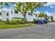 A view of the building surrounded by a lush lawn and trees, complemented by convenient parking spaces at 5042 Marsh Field Rd # 16, Sarasota, FL 34235