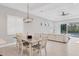 Dining area showcasing modern chandelier, connecting the living area, with view of outdoor pool at 5203 Title Row Dr, Bradenton, FL 34210