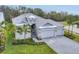 Beautifully landscaped home with a gray exterior, lush lawn, and paved driveway at 5203 Title Row Dr, Bradenton, FL 34210