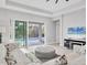Cozy living room featuring a modern sofa, an ottoman, and a view of the pool area at 5203 Title Row Dr, Bradenton, FL 34210