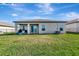 Rear exterior view of the house with covered patio, sliding glass doors, and lake view at 5307 Senza Trl, Palmetto, FL 34221