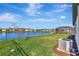 Expansive backyard featuring a lake view and lush green lawn, enhanced by sunny skies at 5307 Senza Trl, Palmetto, FL 34221