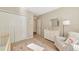 Cozy bedroom featuring plush chair, crib and cream colored wall with decor and a closet at 5307 Senza Trl, Palmetto, FL 34221