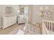 Bright Bedroom featuring a rocking chair, changing table, and a crib at 5307 Senza Trl, Palmetto, FL 34221