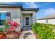 A welcoming entryway with a brick path, lush landscaping, and a stylish front door with decorative wreath at 5307 Senza Trl, Palmetto, FL 34221