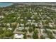 A high-angle view of a neighborhood, filled with lush trees and glimpses of a bay in the background at 577 Corwood Dr, Sarasota, FL 34234