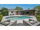 Backyard pool and lounge area with gray wicker furniture and stone pavers at 577 Corwood Dr, Sarasota, FL 34234