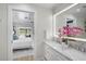 Bright bathroom with dual sinks, illuminated mirror, and seamless transition to the bedroom at 577 Corwood Dr, Sarasota, FL 34234