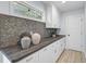 Charming butler's pantry featuring white cabinets, decorative backsplash, and wood-look counter tops at 577 Corwood Dr, Sarasota, FL 34234