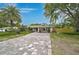 Charming single-story home featuring a long, gray paved driveway, mature landscaping, and a well-maintained front lawn at 577 Corwood Dr, Sarasota, FL 34234