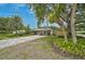 Charming single-story home featuring a long, gray paved driveway, mature landscaping, and a well-maintained front lawn at 577 Corwood Dr, Sarasota, FL 34234