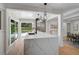 Bright, open kitchen with island, stainless steel appliances, and view of the pool area through sliding doors at 577 Corwood Dr, Sarasota, FL 34234