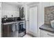 Well-equipped laundry room with stylish tile backsplash, new washer and dryer, and exterior access at 577 Corwood Dr, Sarasota, FL 34234