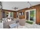 Cozy covered patio featuring comfortable wicker furniture, TV, and string lights at 577 Corwood Dr, Sarasota, FL 34234
