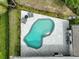 An aerial view showcases an in-ground pool surrounded by gray-toned brick and trimmed hedges at 577 Corwood Dr, Sarasota, FL 34234