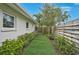 Side yard features faux grass with stone path and manicured landscaping at 577 Corwood Dr, Sarasota, FL 34234