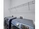 Modern laundry room with full size blue Samsung washer and dryer and storage shelves at 659 Rosemary Cir, Bradenton, FL 34212