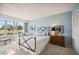 Cozy bedroom featuring light blue walls, a wrought iron bed frame and chair to enjoy views of the greens at 7461 W Country Club N Dr # 207, Sarasota, FL 34243