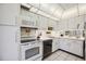 Well-lit kitchen featuring efficient appliances and white cabinetry at 7461 W Country Club N Dr # 207, Sarasota, FL 34243