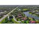 Aerial view featuring a lakefront property with mature trees and lush green landscapes along a scenic road at 7580 Preservation Dr, Sarasota, FL 34241