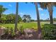 Expansive backyard features a lush green lawn, mature trees, and a serene lake view, offering a private oasis at 7580 Preservation Dr, Sarasota, FL 34241
