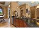 Elegant bar area features dark granite countertops, wood cabinetry, and stainless steel mini fridge at 7580 Preservation Dr, Sarasota, FL 34241