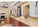 Bathroom with dual sinks, wood cabinetry, neutral countertops, an decorative mirrors for a functional and stylish space at 7580 Preservation Dr, Sarasota, FL 34241