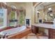 Luxurious bathroom with a soaking tub, large windows, and a vanity area with ample storage at 7580 Preservation Dr, Sarasota, FL 34241