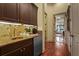 Chic butler's pantry featuring dark cabinetry, granite countertops, and a convenient beverage cooler at 7580 Preservation Dr, Sarasota, FL 34241