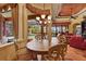 Elegant dining room with round table, ornate chandelier, and views of the pool and outdoor space at 7580 Preservation Dr, Sarasota, FL 34241