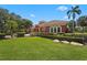Landscaped yard with mature trees and flowering bushes, framing this elegant home at 7580 Preservation Dr, Sarasota, FL 34241