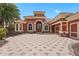 Mediterranean style home boasts a tile roof, red exterior, arched windows, and a spacious driveway, exuding curb appeal at 7580 Preservation Dr, Sarasota, FL 34241