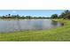 Scenic lake view surrounded by green grass, lush trees, and beautiful homes in a tranquil setting at 7580 Preservation Dr, Sarasota, FL 34241