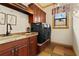 Well-equipped laundry room with washer and dryer, sink and ample cabinet space, providing a functional area at 7580 Preservation Dr, Sarasota, FL 34241