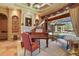 Elegant room with a fireplace, piano, and a view of the pool at 7580 Preservation Dr, Sarasota, FL 34241