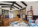 Stylish living room with hardwood floors, vaulted ceilings with wooden beams, and bar with sink at 7580 Preservation Dr, Sarasota, FL 34241