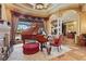 Sitting area boasts large windows, a fireplace, piano, red easy chair, and detailed crown molding at 7580 Preservation Dr, Sarasota, FL 34241