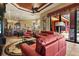 Cozy living room with red leather sofas, a decorative rug, and access to the outdoor patio and pool at 7580 Preservation Dr, Sarasota, FL 34241