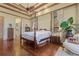 Spacious bedroom with hardwood floors, four-poster bed, and plenty of natural light at 7580 Preservation Dr, Sarasota, FL 34241