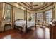 Serene bedroom with a four-poster bed, hardwood floors, and bay windows at 7580 Preservation Dr, Sarasota, FL 34241