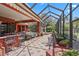 A spacious screened-in patio with an outdoor bar, pool, and lush landscaping offers the perfect outdoor living space at 7580 Preservation Dr, Sarasota, FL 34241