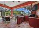 Covered outdoor kitchen featuring bar seating, a ceiling fan, grill area, providing a great space for entertaining guests at 7580 Preservation Dr, Sarasota, FL 34241