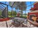 A screened-in patio with an outdoor fireplace and dining area is perfect for entertaining at 7580 Preservation Dr, Sarasota, FL 34241