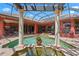 A tranquil, screened pool area is framed by pillars, lush plants, and elegant architecture at 7580 Preservation Dr, Sarasota, FL 34241