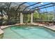 A pristine pool with fountain features, surrounded by lush greenery and a black aluminum enclosure, offering a tranquil oasis at 7580 Preservation Dr, Sarasota, FL 34241