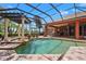 A screened-in pool with lounge chairs, a covered dining area, and lush landscaping is great for outdoor living at 7580 Preservation Dr, Sarasota, FL 34241