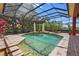 Screened-in pool area featuring a fountain, landscaping, and a seating area for relaxation at 7580 Preservation Dr, Sarasota, FL 34241