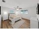 Cozy bedroom featuring wood floors, ceiling fan, and natural light from two windows at 7797 Barry Ct, Seminole, FL 33772